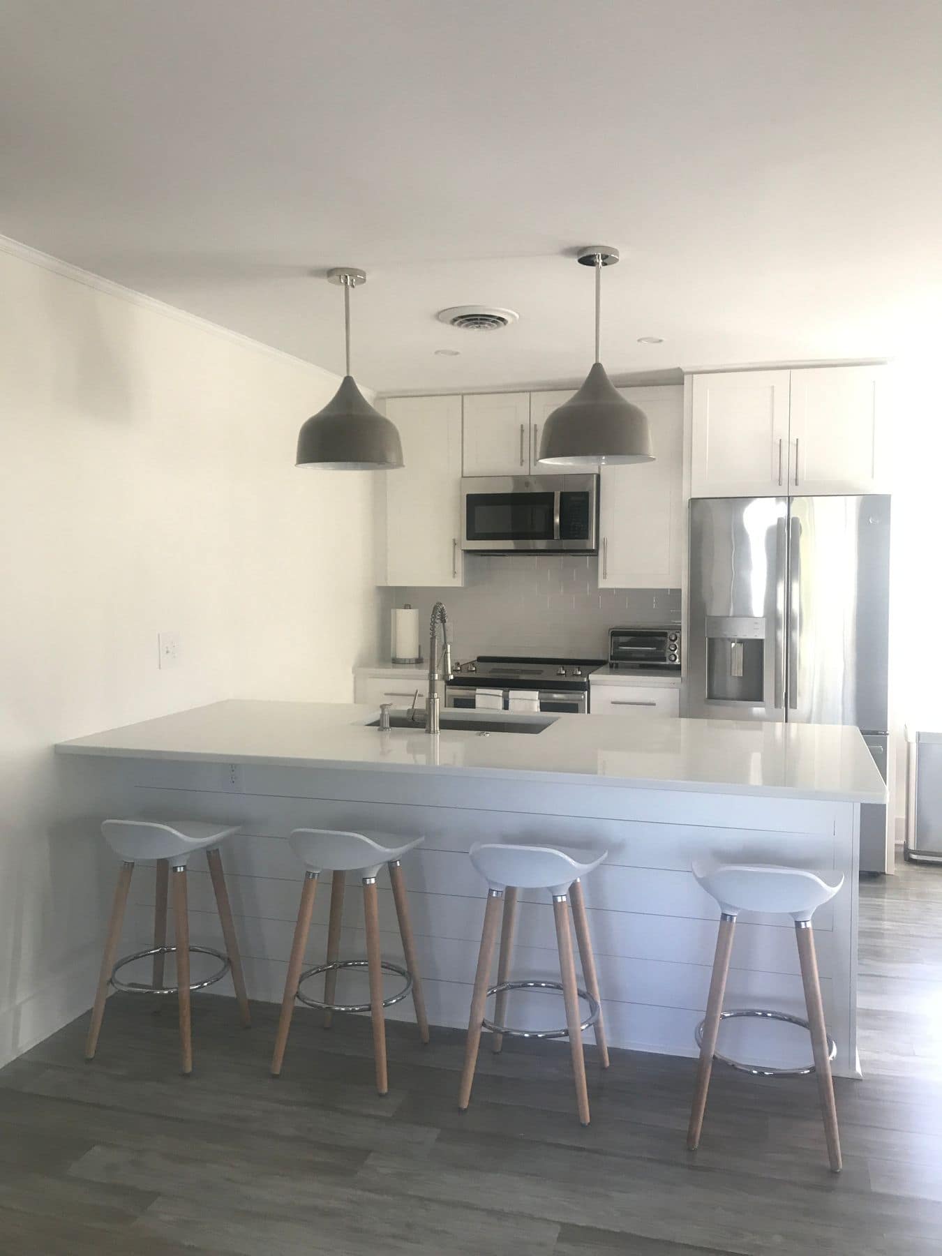 The peninsula with four stools and a shiplap panel