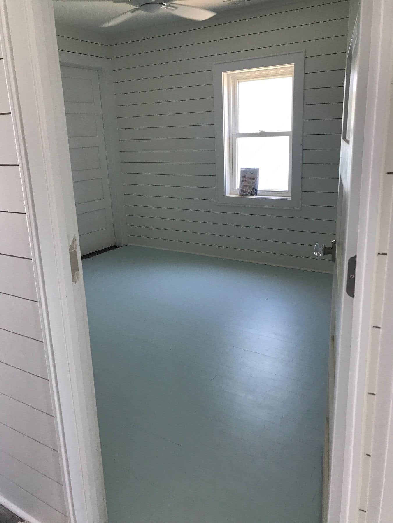 A bedroom finished in white shiplap