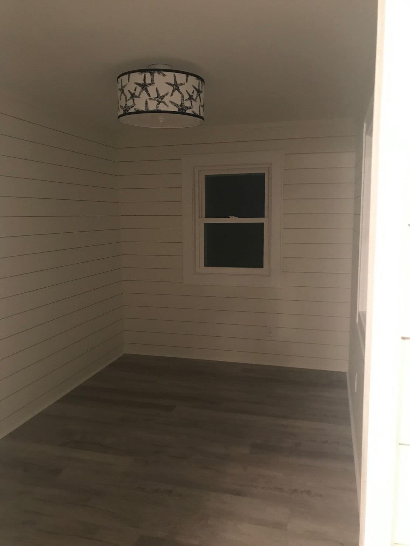 A shiplap room with a starfish ceiling light
