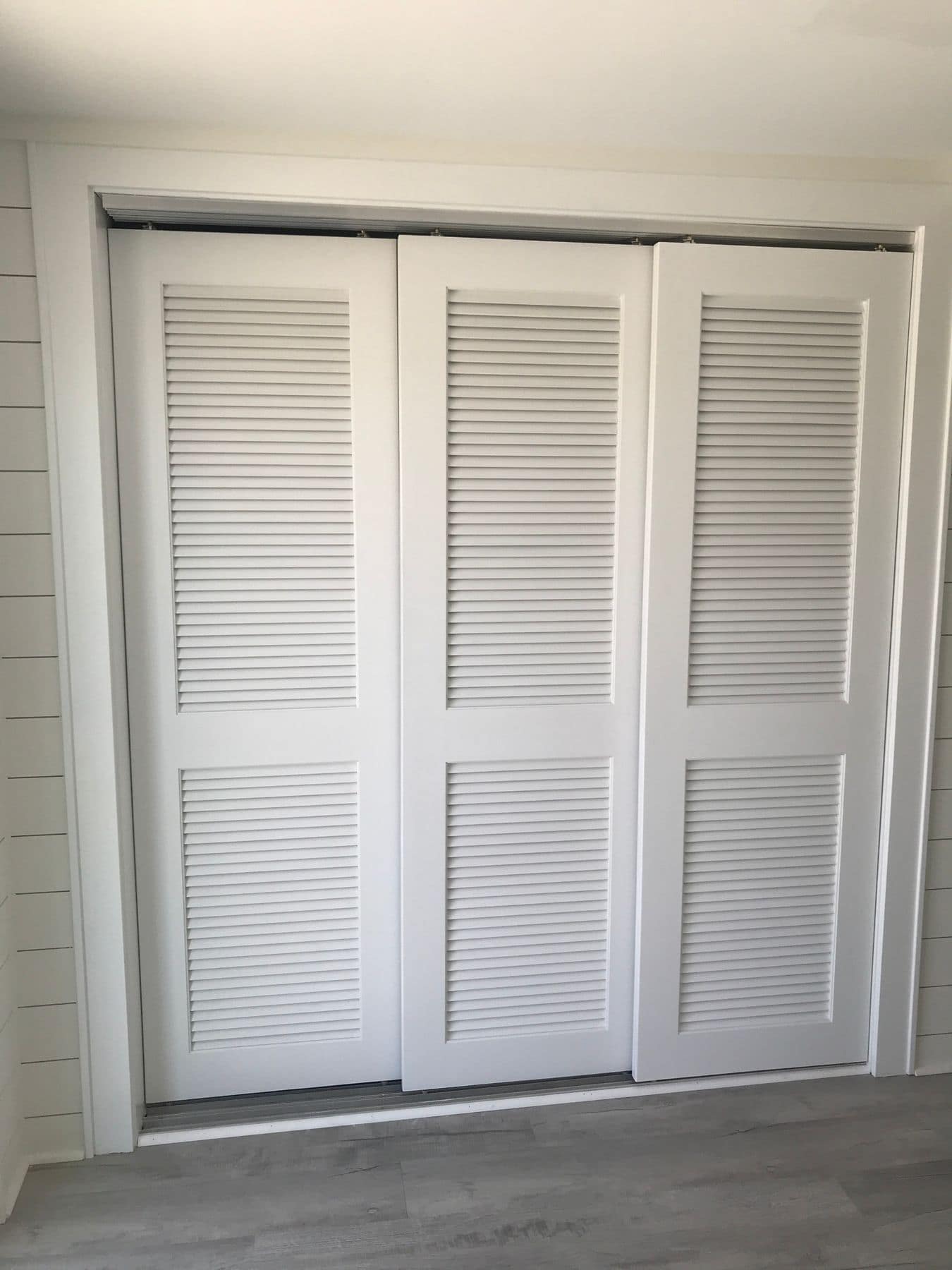 Louvered closet doors in a shiplap wall