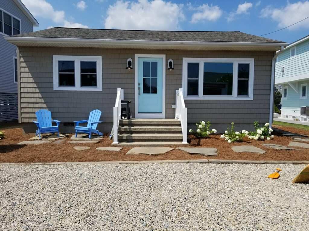 The finished cottage front walk with flagstones, white rails, and new plantings