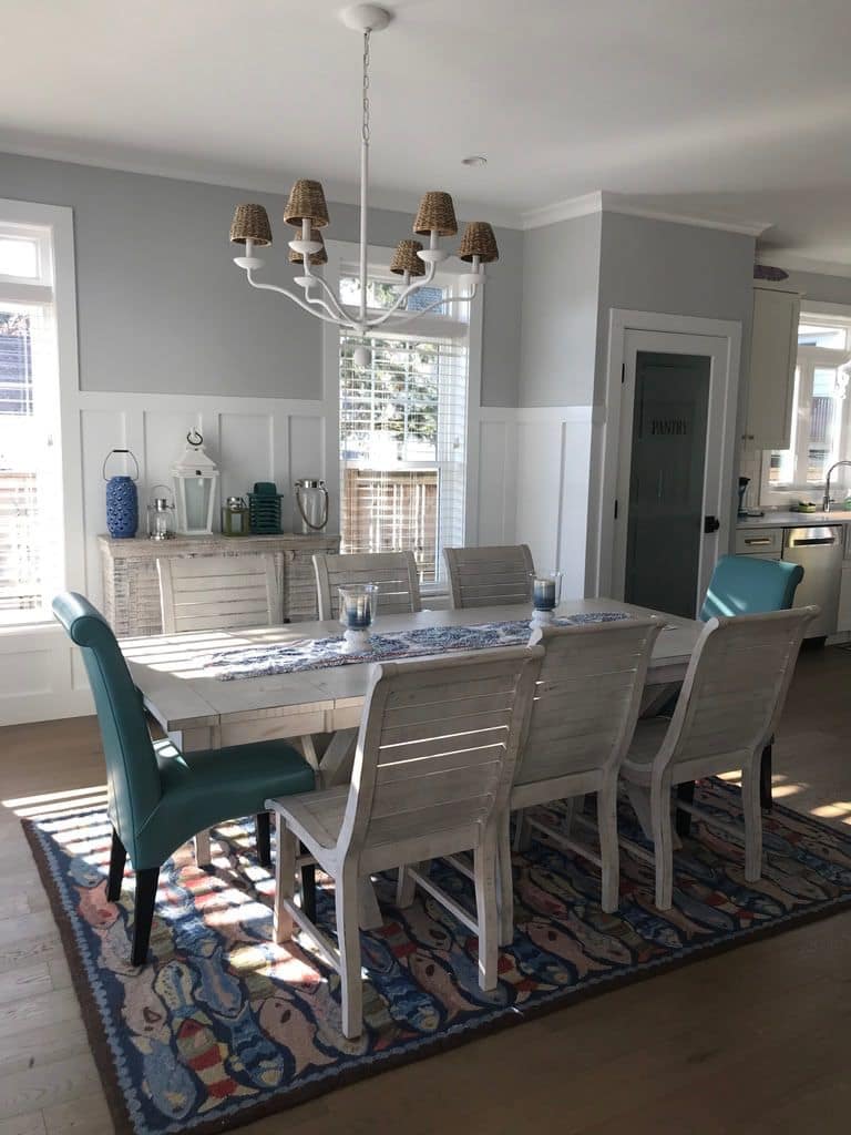 Dining table under a shaded chandelier beside the kitchen
