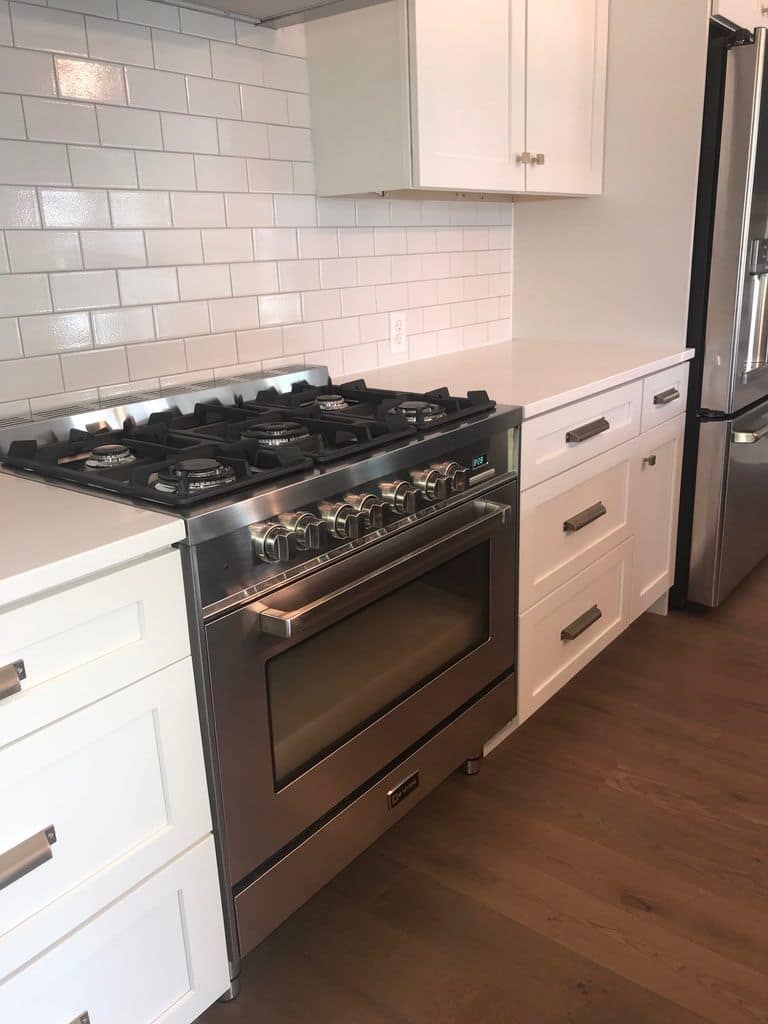 Gas range set into white subway tile