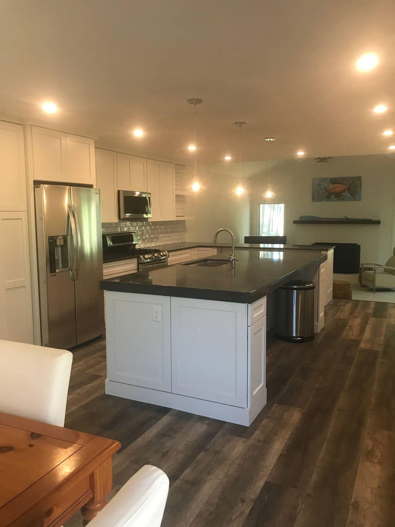 After: the wall is gone and the kitchen opens to the living room around an island