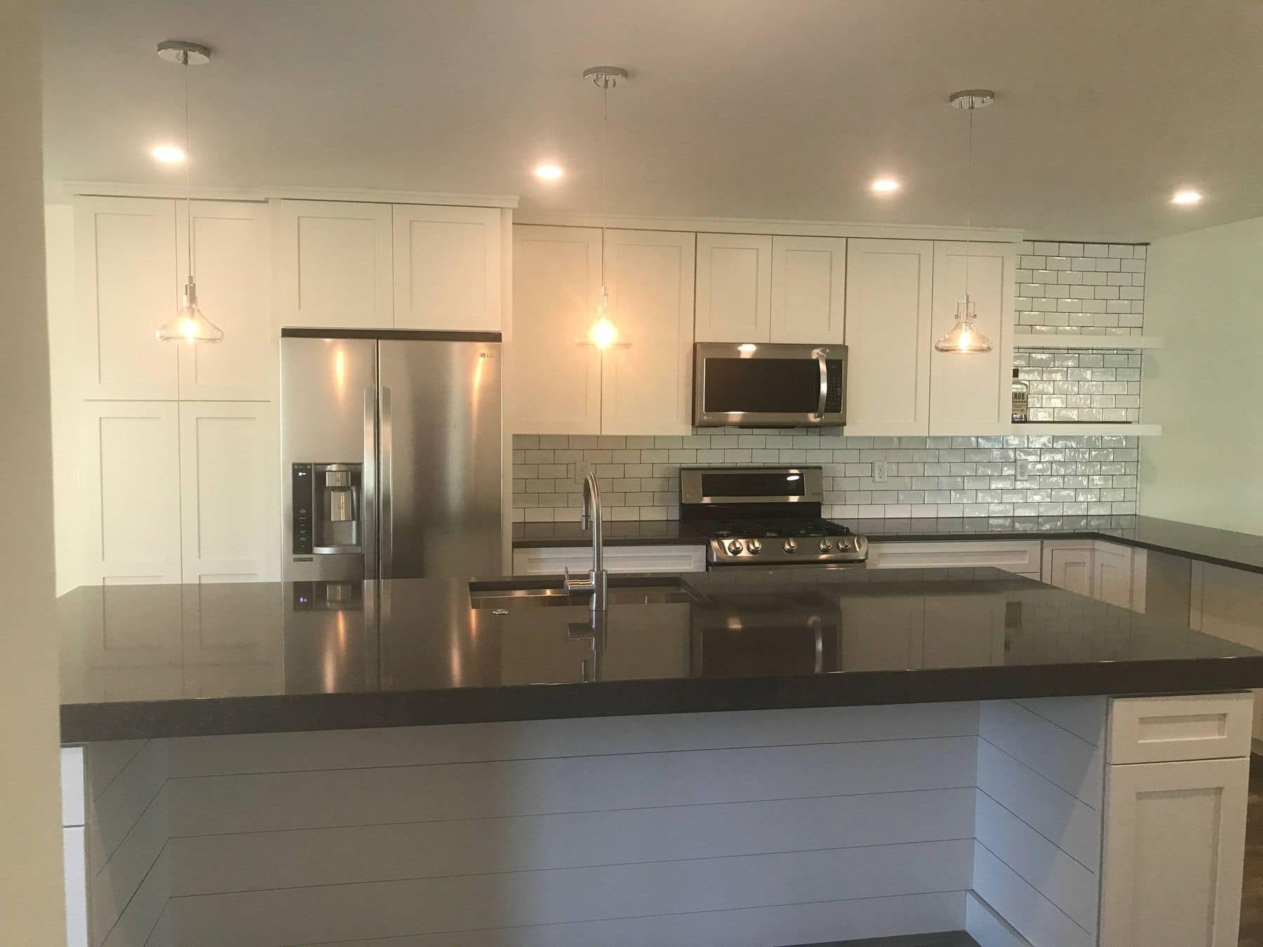 White shaker kitchen with subway tile and dark counters